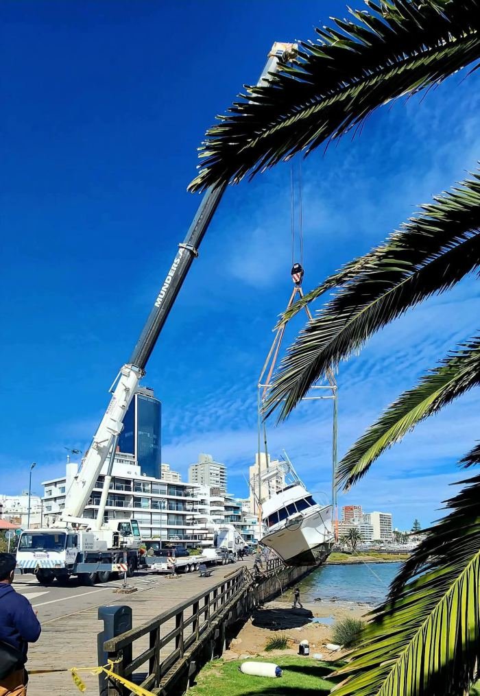 Grúa Rosano trabajando junto a velero en marina deportiva, Uruguay