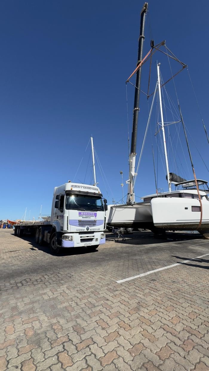 Camión Rosano con acoplado plataforma y veleros en puerto deportivo, Uruguay