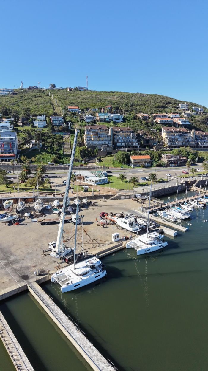 Grúa Rosano en operativo de izaje en muelle con vista al cerro, Uruguay