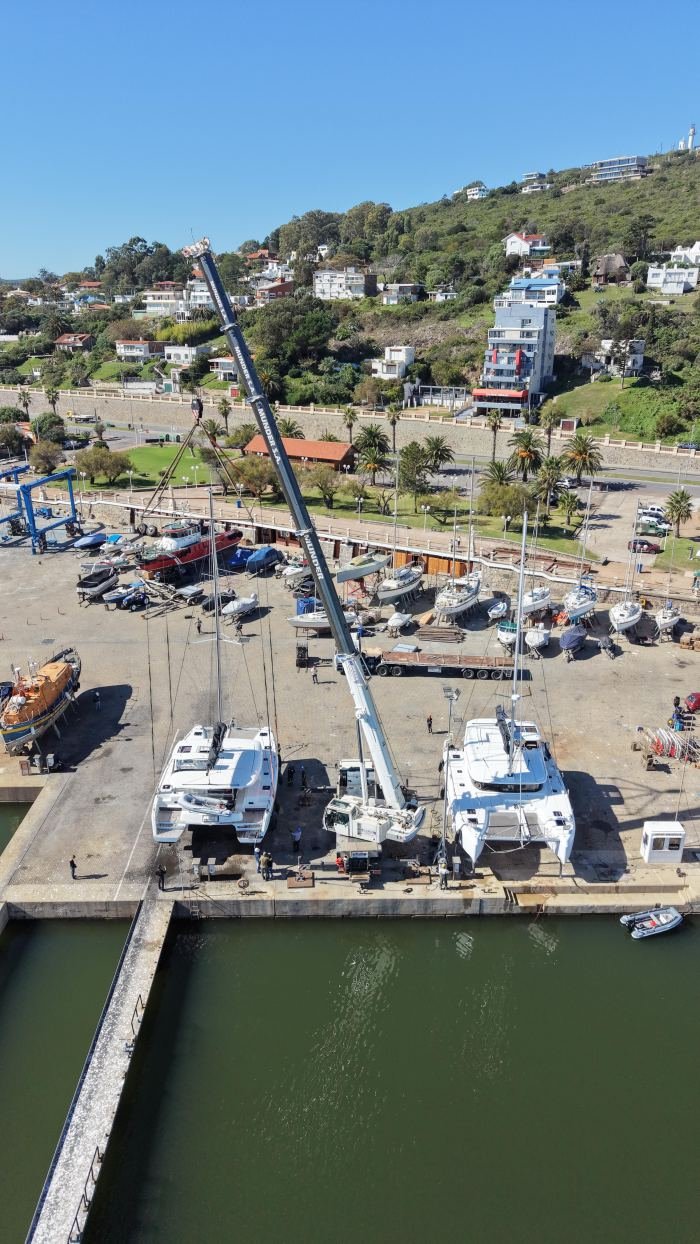 Vista aérea de puerto deportivo con grúa Rosano en operación de izaje, Maldonado